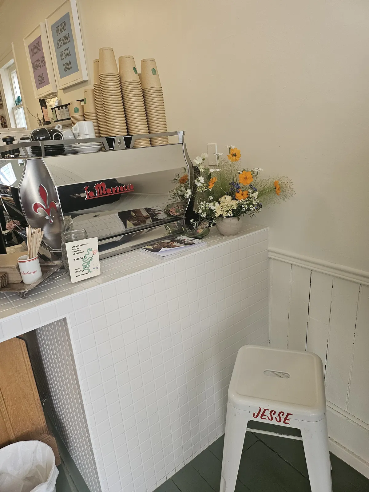 The espresso bar with stacked cups and fresh flowers
