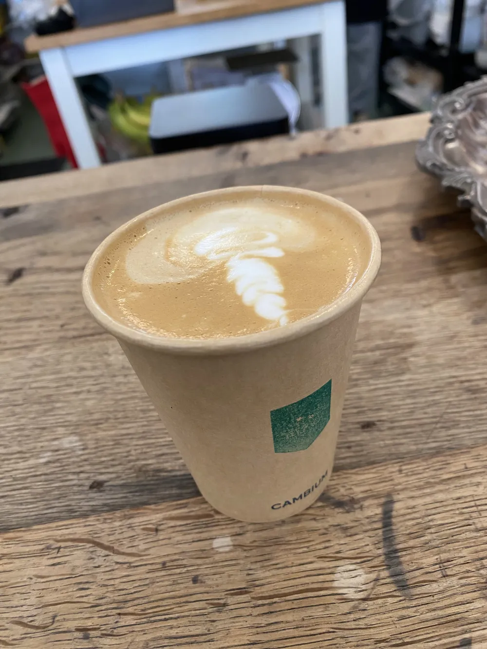A latte with leaf art in a citizen frances cup