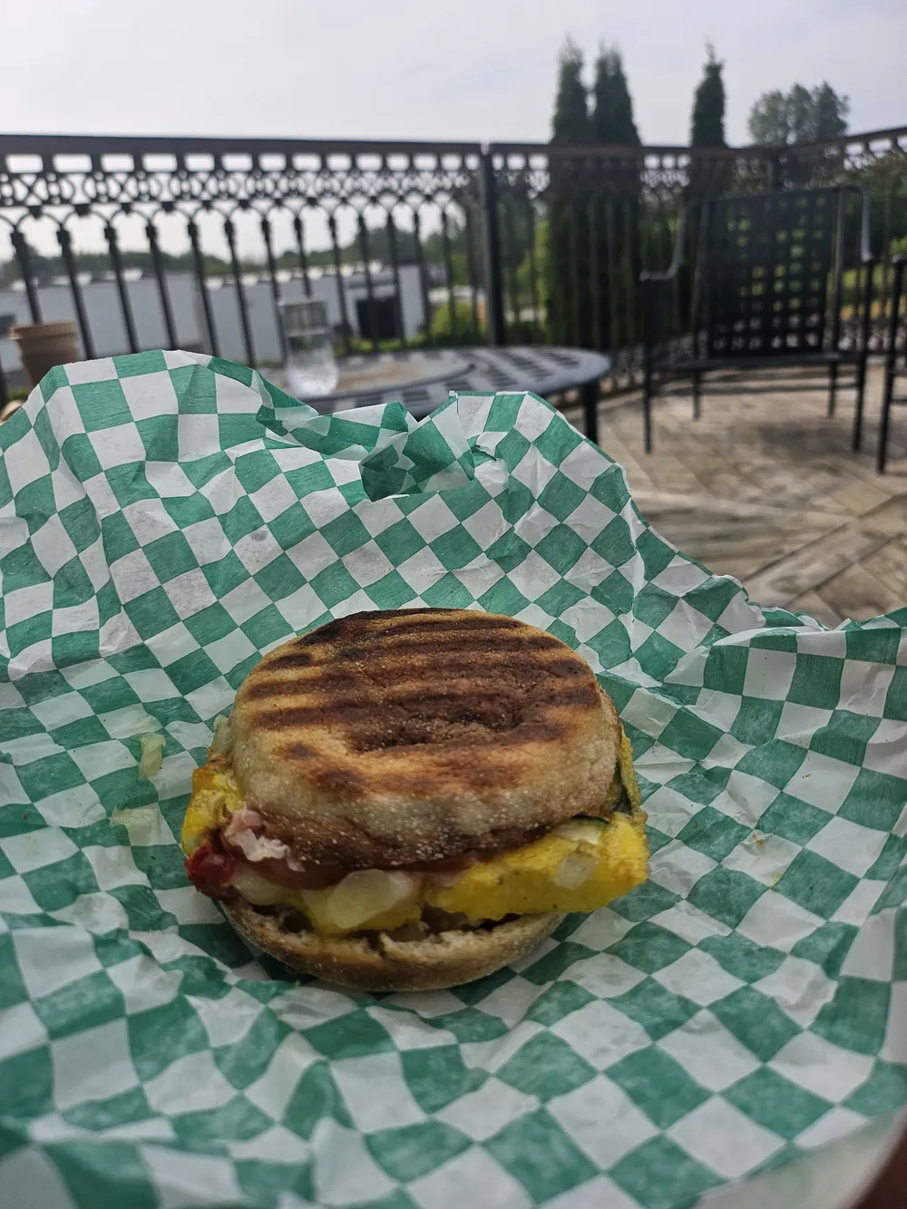 A breakfast sandwich on green checked paper
